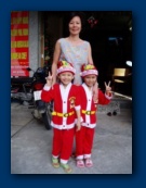 Linh with Tuyen and Y Pao, all dressed up for Santa's visit.